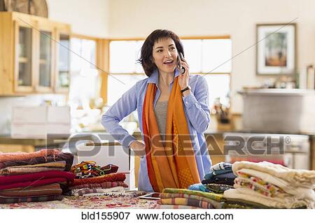 Hispanic business owner talking on telephone in home office View Large Photo Image Stock Photo - Hispanic business owner talking on telephone in home office. Fotosearch