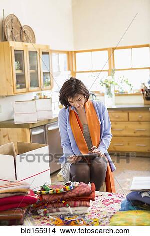Hispanic business owner using digital tablet in home office View Large Photo Image Picture - Hispanic business owner using digital tablet in home office. Fotosearch