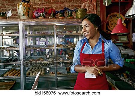 Hispanic waitress taking orders in bakery View Large Photo Image Stock Photograph - Hispanic waitress taking orders in bakery. Fotosearch