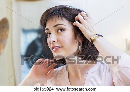 Hispanic woman admiring hair in mirror View Large Photo Image Picture - Hispanic woman admiring hair in mirror. Fotosearch