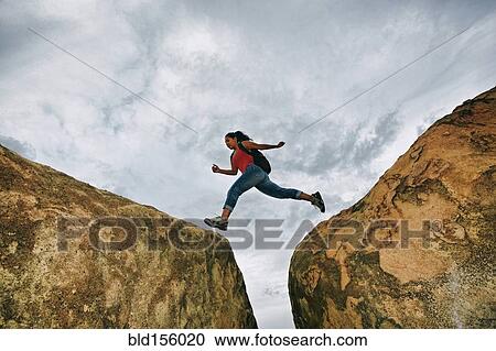 Hispanic woman jumping crevasse on rock formations View Large Photo Image Stock Image - Hispanic woman jumping crevasse on rock formations. Fotosearch