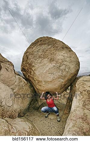 Hispanic woman lifting boulder on rocky hillside View Large Photo Image Stock Photo - Hispanic woman lifting boulder on rocky hillside. Fotosearch