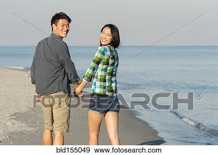 Korean couple walking on beach View Large Photo Image Stock Photo - Korean couple walking on beach. Fotosearch
