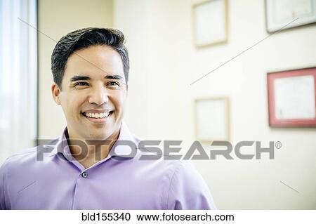Stock Image - Mixed race businessman smiling in office. Fotosearch