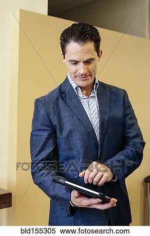 Mixed race businessman using digital tablet in office View Large Photo Image Stock Photography - Mixed race businessman using digital tablet in office. Fotosearch