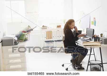 Mixed race businesswoman working at desk View Large Photo Image Stock Photography - Mixed race businesswoman working at desk. Fotosearch