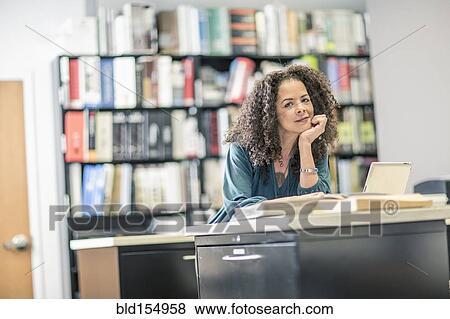 Stock Photo - Mixed race businesswoman working in office. Fotosearch