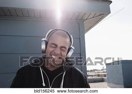 Mixed race man listening to headphones outdoors View Large Photo Image Stock Photography - Mixed race man listening to headphones outdoors. Fotosearch