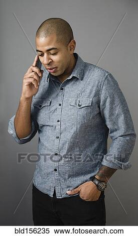 Stock Photography - Mixed race man talking on cell phone. Fotosearch