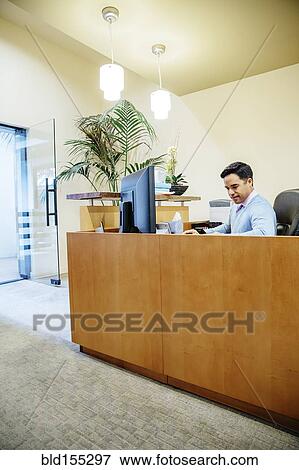 Stock Photo - Mixed race secretary working in office lobby. Fotosearch