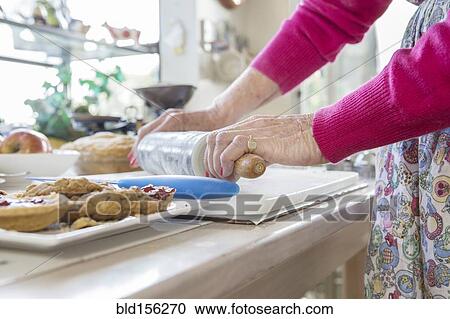 Stock Image - Older Caucasian woman baking pie in kitchen. Fotosearch