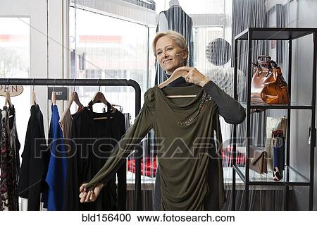 Older Caucasian woman shopping in clothing store View Large Photo Image Stock Image - Older Caucasian woman shopping in clothing store. Fotosearch