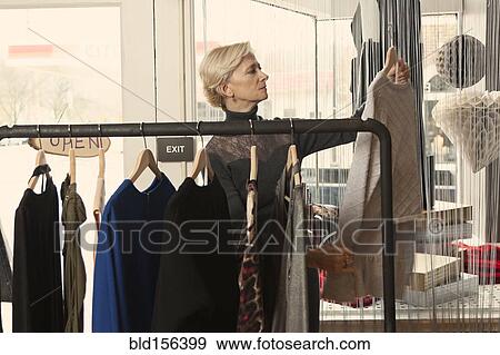 Stock Photo - Older Caucasian woman shopping in clothing store. Fotosearch