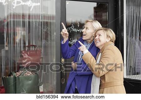 Picture - Older Caucasian women window shopping in clothing store. Fotosearch