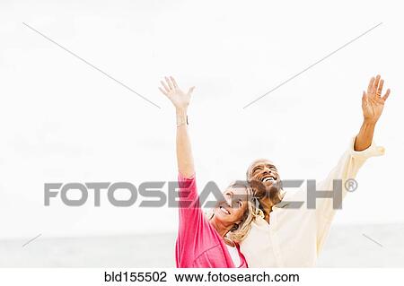 Older couple cheering and hugging on beach View Large Photo Image Stock Image - Older couple cheering and hugging on beach. Fotosearch