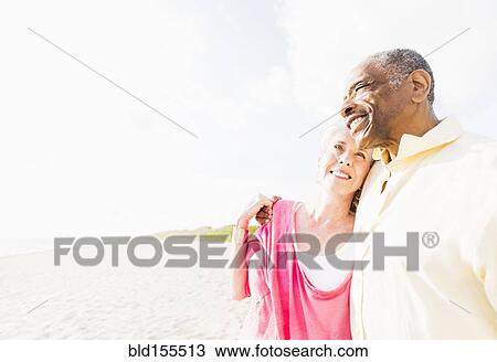 Older couple hugging on beach View Large Photo Image Stock Image - Older couple hugging on beach. Fotosearch