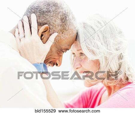 Older couple touching foreheads on beach View Large Photo Image Stock Photo - Older couple touching foreheads on beach. Fotosearch
