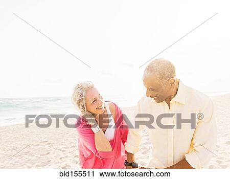 Older couple walking on beach View Large Photo Image Stock Image - Older couple walking on beach. Fotosearch
