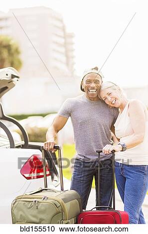 Stock Image - Older couple with luggage on vacation. Fotosearch