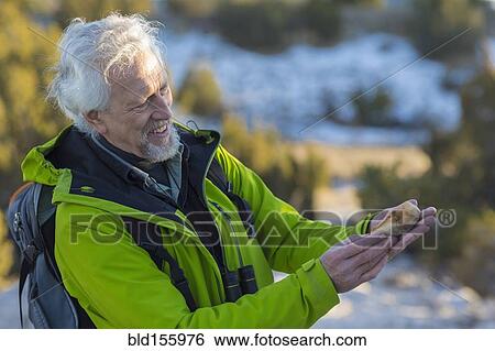 Older man admiring rock on hike View Large Photo Image Stock Photograph - Older man admiring rock on hike. Fotosearch