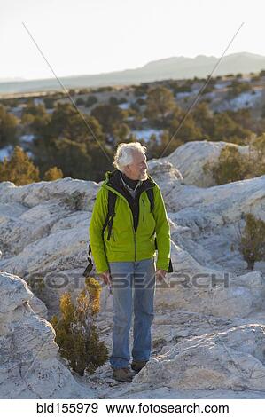 Older man standing on remote rock formations View Large Photo Image Stock Photo - Older man standing on remote rock formations. Fotosearch