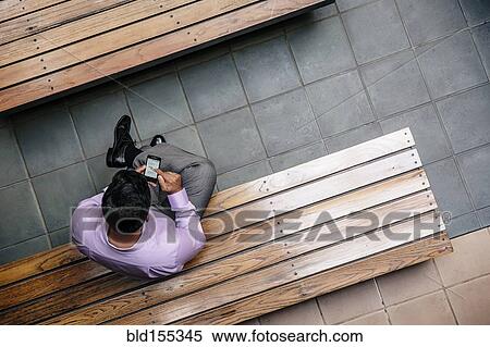 Overhead view of mixed race businessman using cell phone in office courtyard View Large Photo Image Stock Photography - Overhead view of mixed race businessman using cell phone in office courtyard. Fotosearch