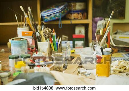 Stock Photo - "Paintbrushes, pencils and art tools on studio desk". Fotosearch