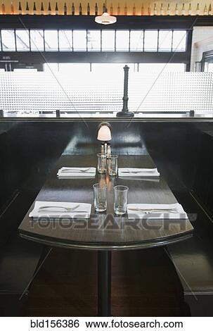 Place settings on empty booth table in restaurant View Large Photo Image Stock Photograph - Place settings on empty booth table in restaurant. Fotosearch