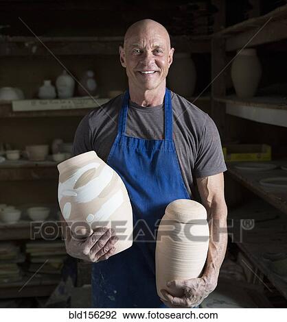 Proud older Caucasian man holding pottery in ceramics studio View Large Photo Image Stock Image - Proud older Caucasian man holding pottery in ceramics studio. Fotosearch
