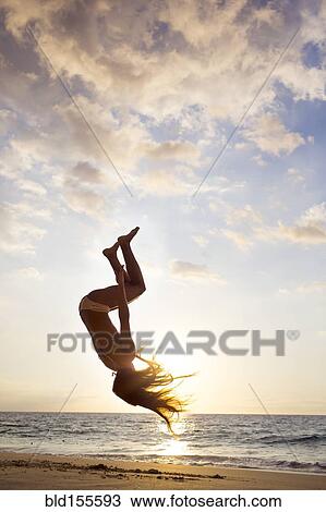 Silhouette of mixed race woman doing backflip on beach View Large Photo Image Stock Image - Silhouette of mixed race woman doing backflip on beach. Fotosearch