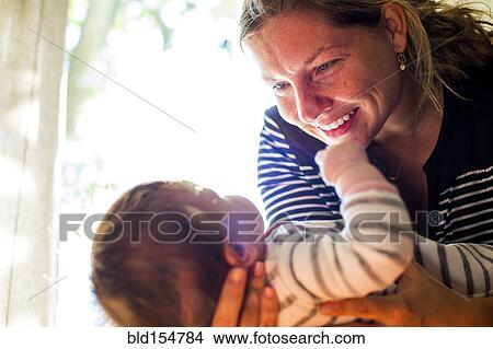 Smiling Caucasian mother cradling baby girl View Large Photo Image Picture - Smiling Caucasian mother cradling baby girl. Fotosearch