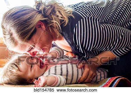 Stock Photography - Smiling Caucasian mother cradling baby girl. Fotosearch