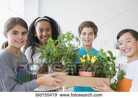 Stock Photo - Smiling children holding potted plants. Fotosearch