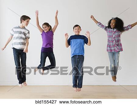 Stock Photo - Smiling children jumping for joy in studio. Fotosearch