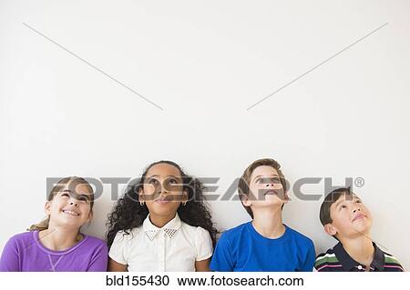 Stock Image - Smiling children thinking and looking up. Fotosearch
