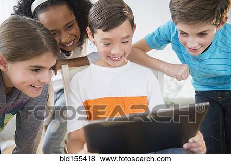 Smiling children using digital tablet View Large Photo Image Stock Photo - Smiling children using digital tablet. Fotosearch