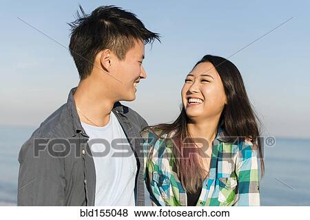 Smiling Korean couple hugging on beach View Large Photo Image Stock Photo - Smiling Korean couple hugging on beach. Fotosearch