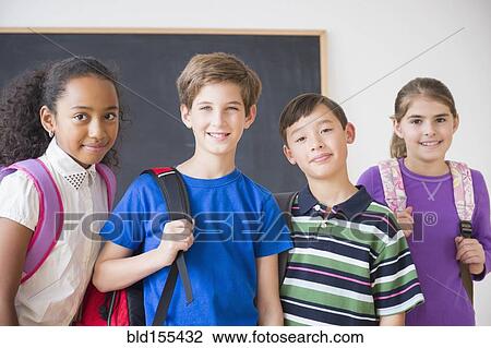 Smiling students wearing backpacks in front of chalkboard View Large Photo Image Stock Image - Smiling students wearing backpacks in front of chalkboard. Fotosearch