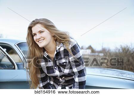 Smiling woman leaning on vintage car View Large Photo Image Stock Photograph - Smiling woman leaning on vintage car. Fotosearch