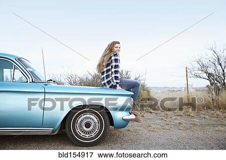 Smiling woman sitting on vintage car View Large Photo Image Stock Photo - Smiling woman sitting on vintage car. Fotosearch