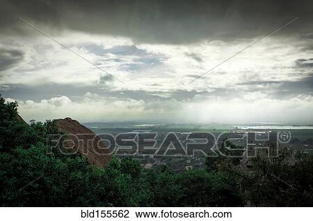 Stock Image - Storm clouds over treetops in rural landscape. Fotosearch