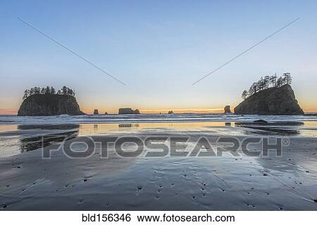 Sunrise horizon behind rock formations on beach View Large Photo Image Stock Photograph - Sunrise horizon behind rock formations on beach. Fotosearch