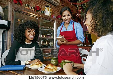 Waitress serving customers in cafe View Large Photo Image Stock Photography - Waitress serving customers in cafe. Fotosearch