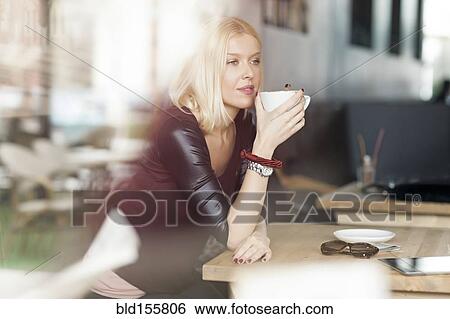 Stock Photograph - Woman drinking cup of coffee in cafe. Fotosearch