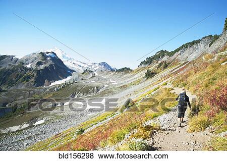 Stock Photo - Woman hiking on rocky trail on remote hillside. Fotosearch