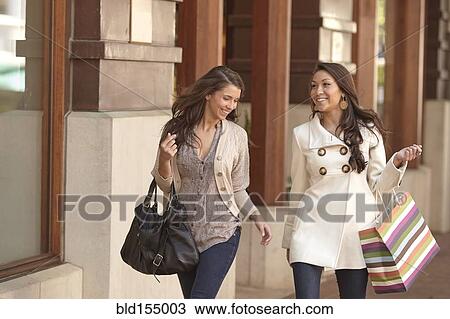 Women carrying shopping bags on sidewalk View Large Photo Image Stock Image - Women carrying shopping bags on sidewalk. Fotosearch