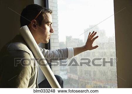 Stock Photo - Caucasian architect looking out office window. Fotosearch