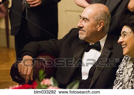 Stock Image - Hispanic family in formal wear sitting at wedding. Fotosearch