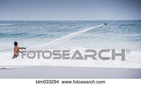 Man watching boat in ocean waves from beach View Large Photo Image Picture - Man watching boat in ocean waves from beach. Fotosearch
