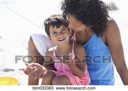 Mixed race mother and daughter playing on beach View Large Photo Image Stock Image - Mixed race mother and daughter playing on beach. Fotosearch